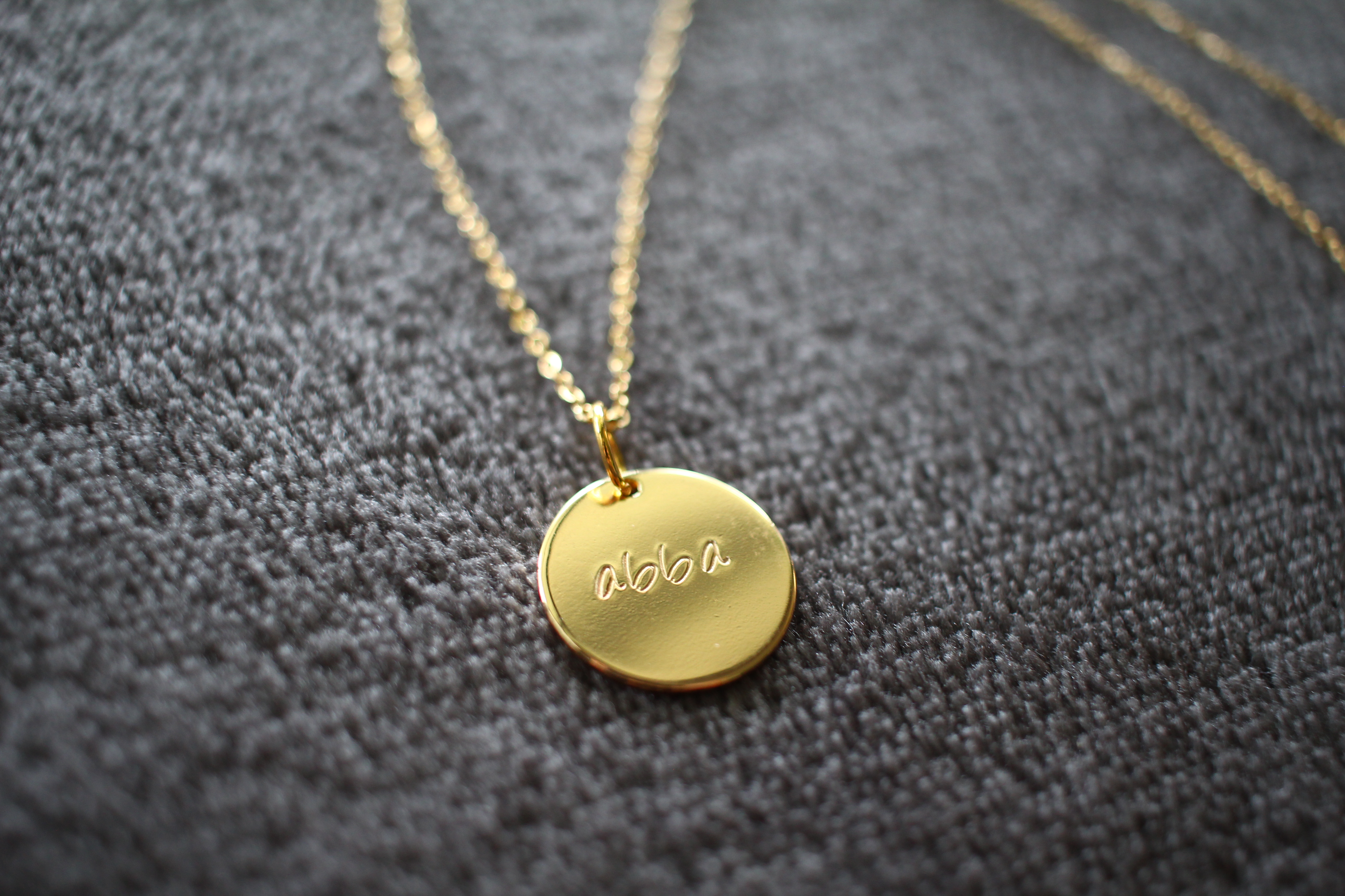 Gold necklace with 'Abba' written on it