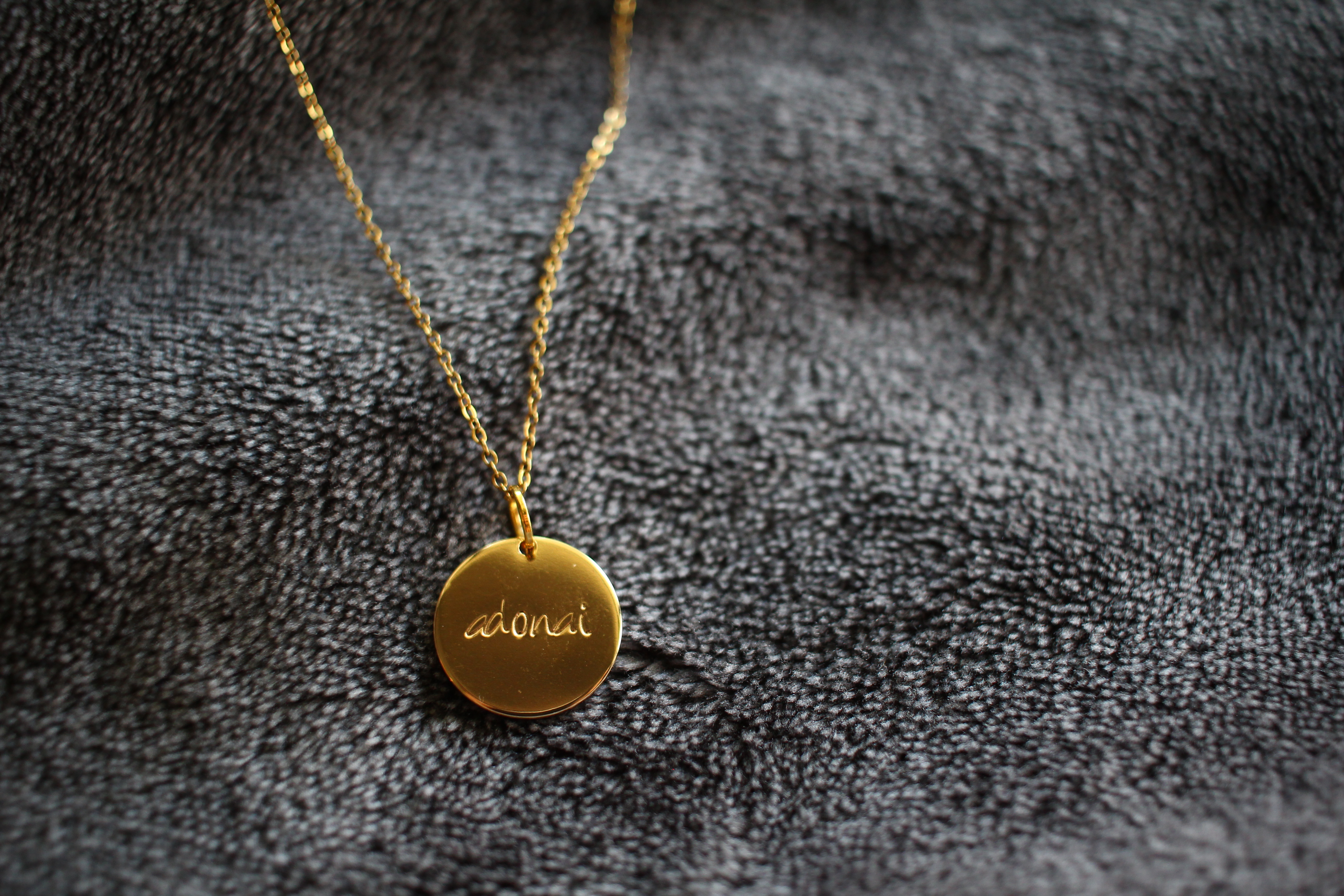 Gold necklace with 'Adonai' written on it