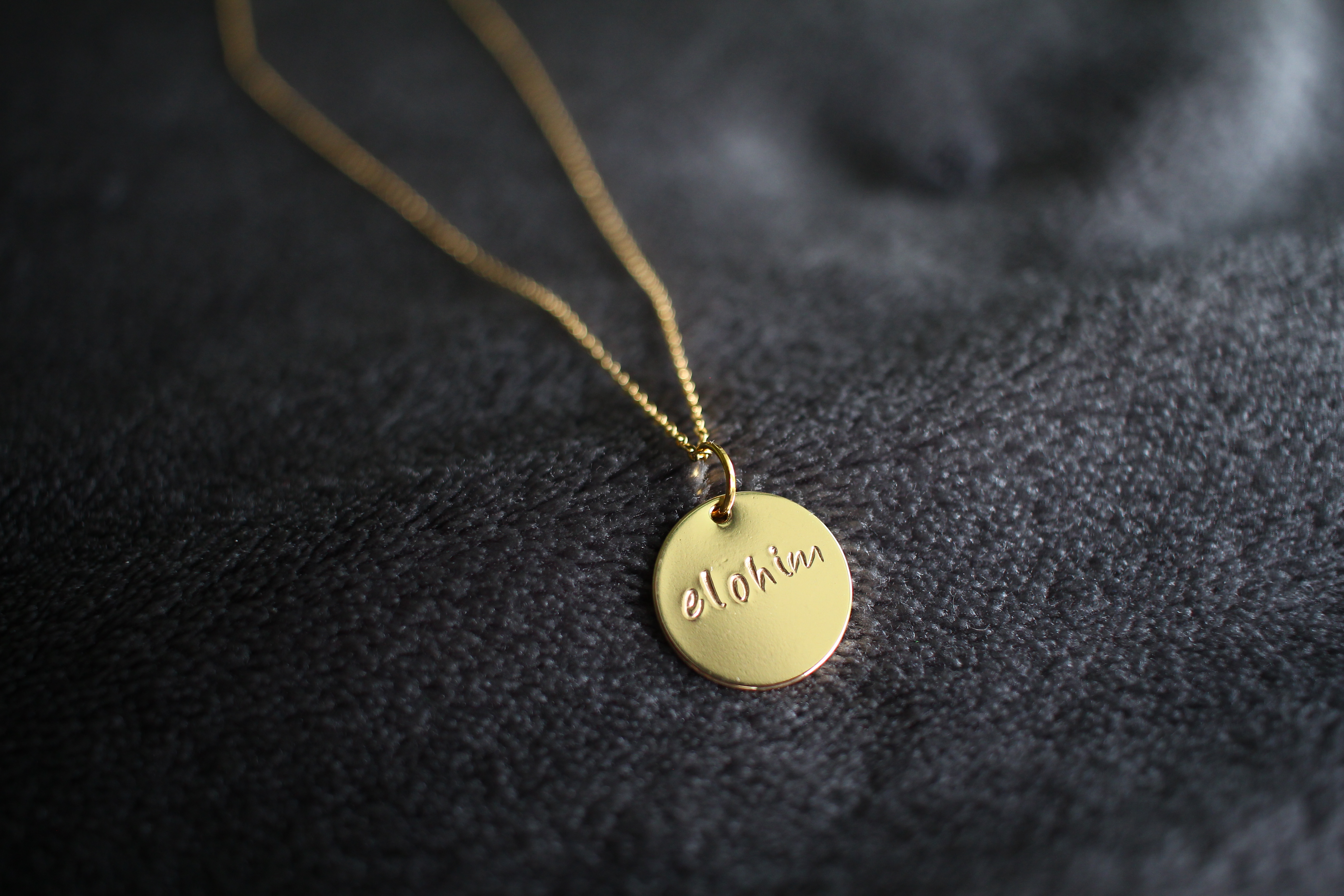 Gold necklace with 'Elohim' written on it