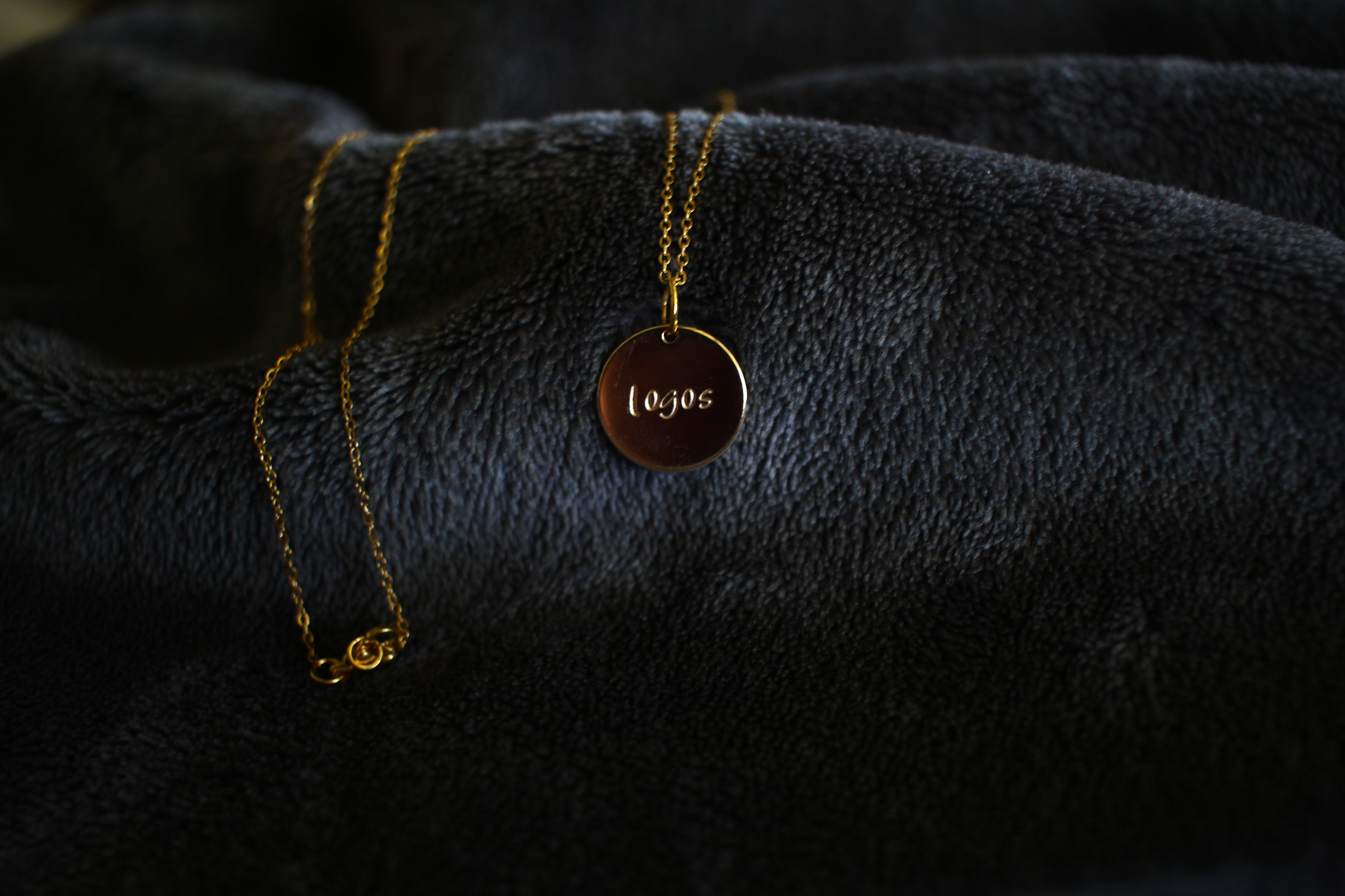 Gold necklace with 'Logos' written on it